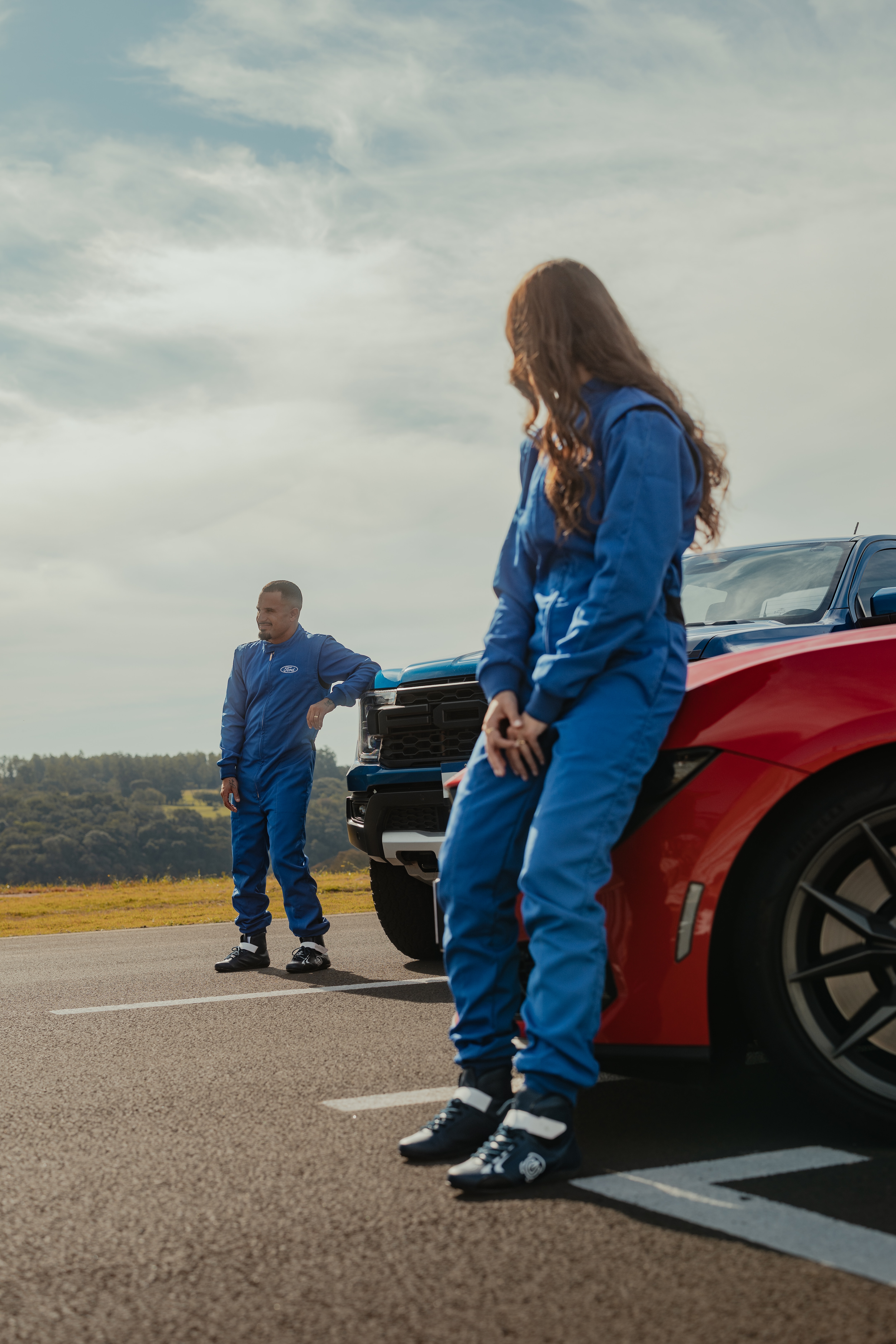 Piloto Rafaela Ferreira e o surfista Ítalo Ferreira na pista com o Mustang Dark Horse vermelho e a picape Ranger Raptor azul